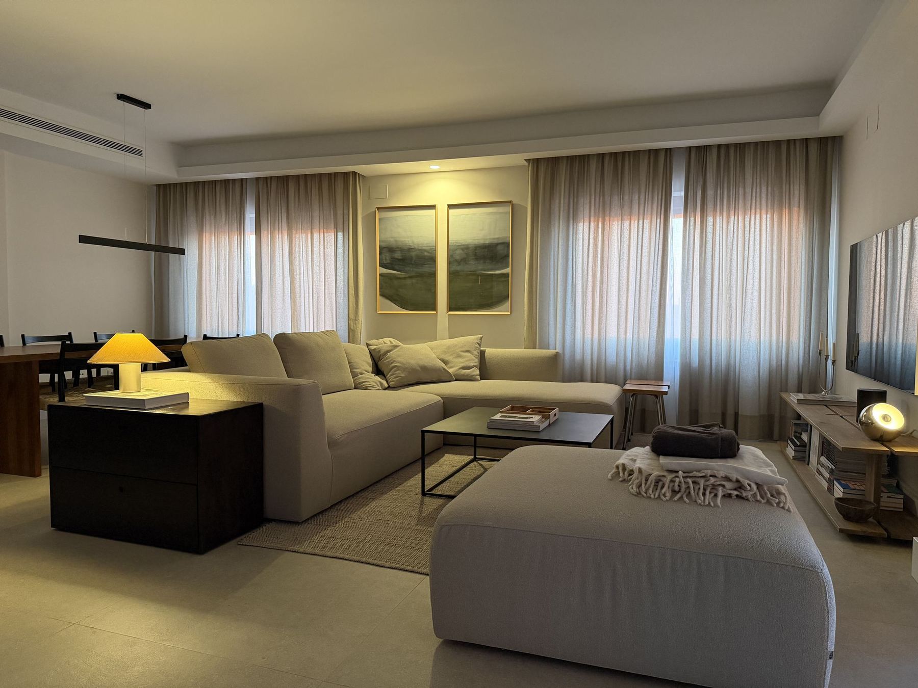 Salón principal con sofá, mesa de centro y grandes ventanales